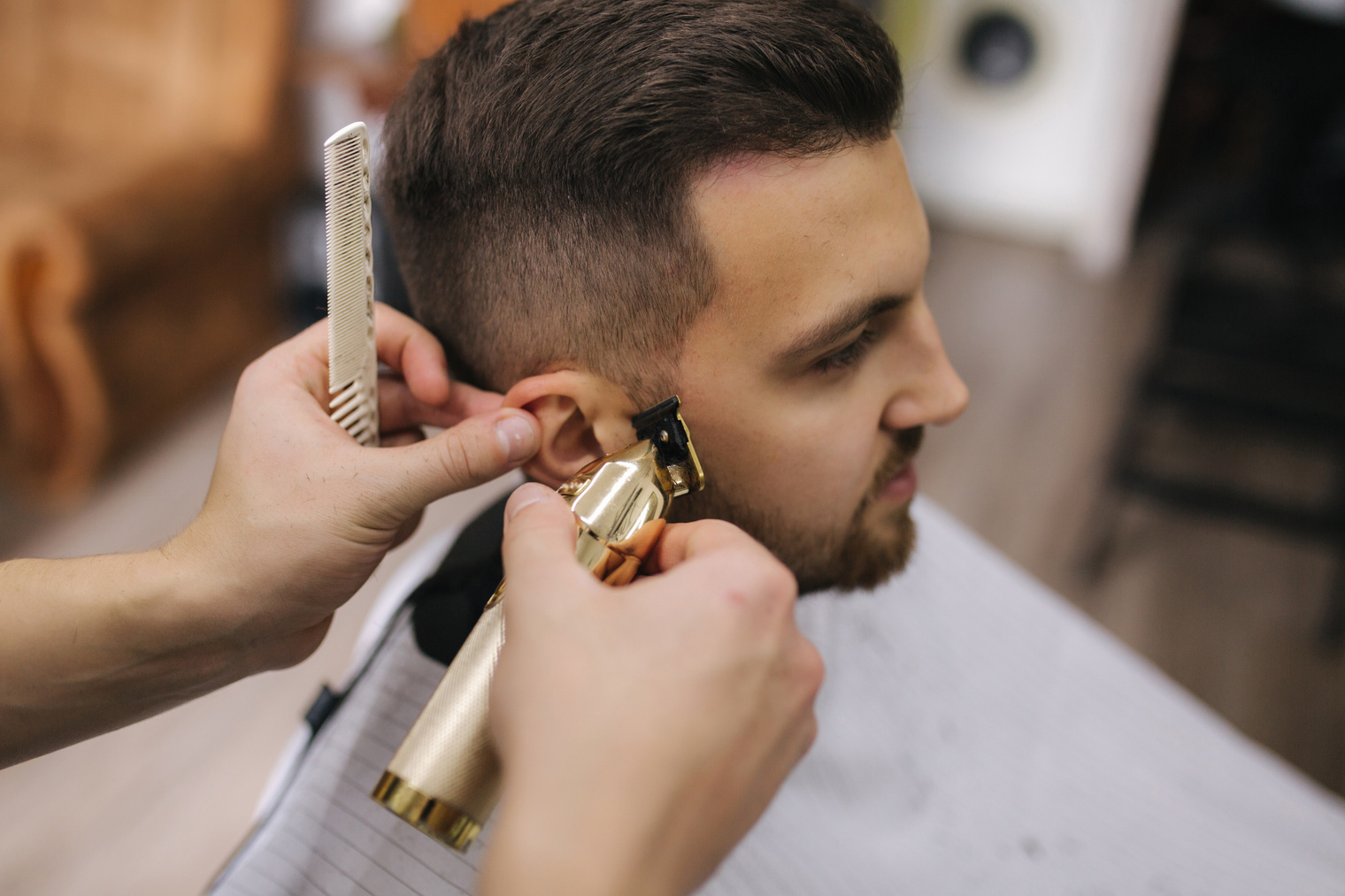 Hairdresser using Hair Clipper for Fringing Hair of Bearded Man